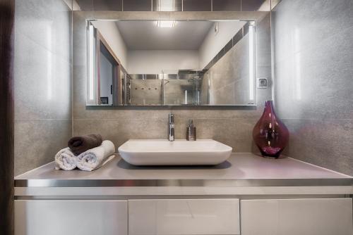 a bathroom with a sink and a mirror at Apartament Superior de Lux - Porta Mare in Dziwnówek