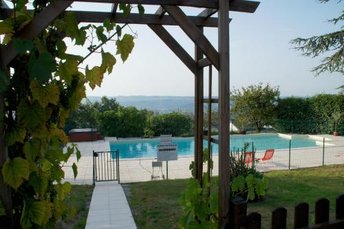 a view of a swimming pool from a garden at Logis hotel-restaurant les collines 59 route des crêtes in Cublac