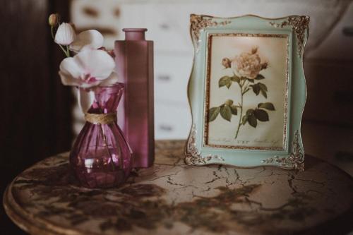 a table with a vase and a picture and flowers at Filoxenia- Drakia in Drakeia