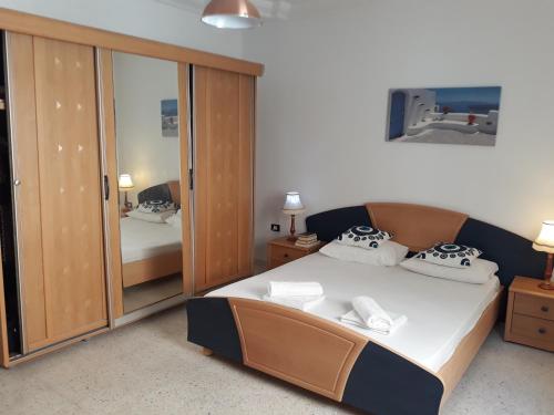 1 dormitorio con cama y espejo grande en Villa Bougainvillier en Sousse
