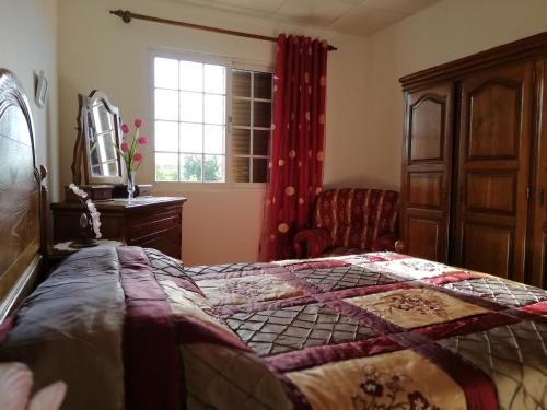 a bedroom with a bed and a chair and a window at Casa Conceição in Atalaia