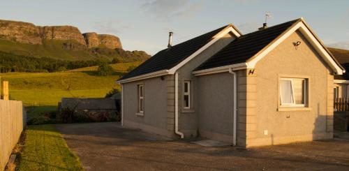 a small house with a mountain in the background at Atlantic View Apartments in Limavady