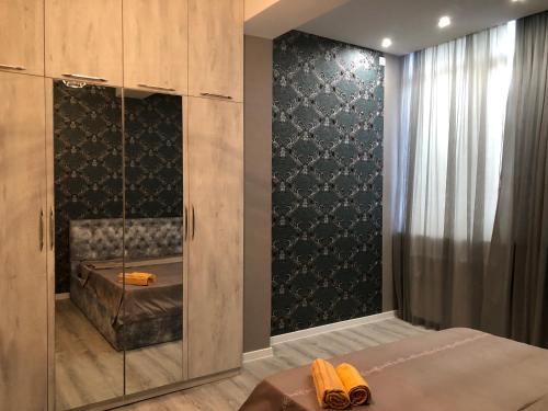 a bedroom with a bed and a glass wall at Dona Palace Apartments in Tbilisi City