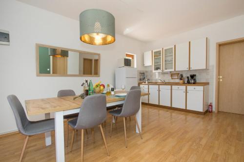 Una cocina y un comedor con mesa y sillas. en Villa Maximilian, en Grebaštica