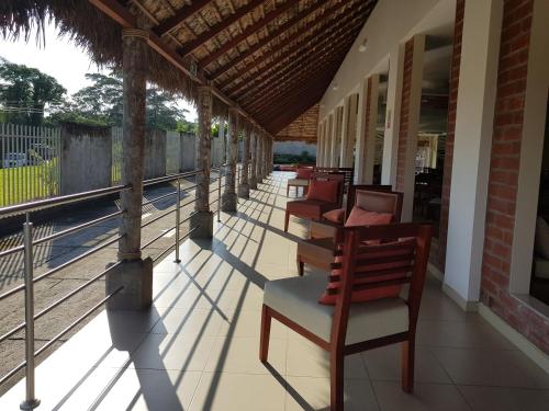 een rij stoelen en tafels op een veranda bij Gran Hotel de Lago - Shushufindi in Shushufindi
