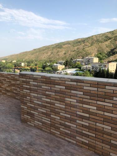 a brick wall with a view of a city at Dona Palace Apartments in Tbilisi City