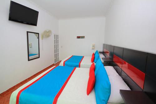 a bedroom with a large bed with blue and red pillows at Glamping Girardot & Hotel Puerta Del Sol Girardot in La Virginia