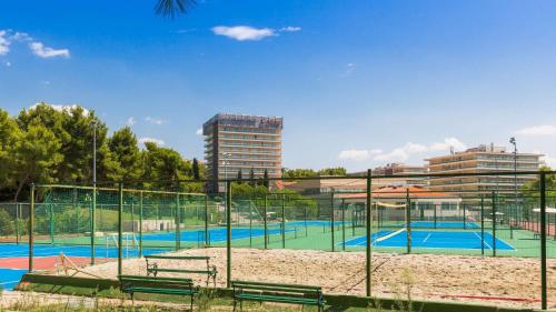 a tennis court with benches in front of a building at Lavica Seaside Apartments, Podstrana in Podstrana