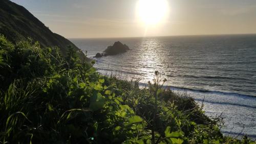 a view of the ocean from a hill with the sun setting at SF Ocean View Rentals in Pacifica