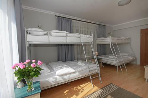 um quarto com dois beliches com um vaso de flores em Apartamenty Dorotowo em Dorotowo