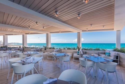a restaurant with tables and chairs and the ocean at Condado Ocean Club - Adults Only in San Juan