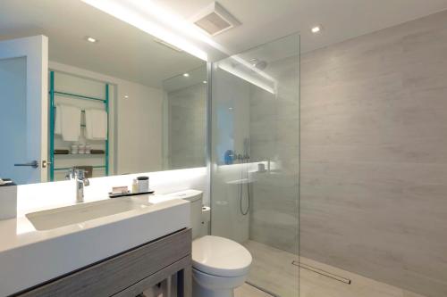 a bathroom with a toilet and a glass shower at Condado Ocean Club in San Juan