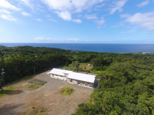 an aerial view of a building with the ocean in the background at Yakunoyado Taguchi in Yakushima