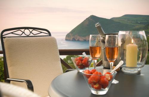 a table with a candle and two glasses of wine at Sandy Cove Hotel in Ilfracombe