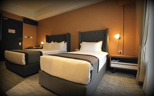 a hotel room with two beds in a room at 1969 Business Suites Bandar Botani, Ipoh in Ipoh