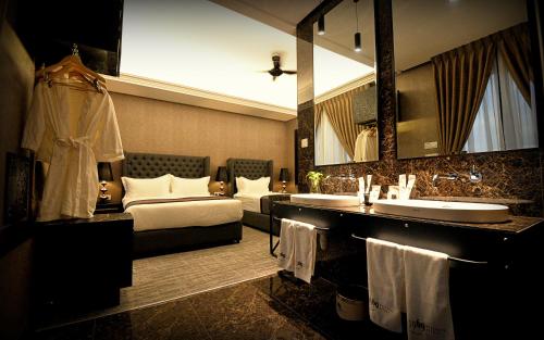 a bathroom with a bed and a sink and a mirror at 1969 Business Suites Bandar Botani, Ipoh in Ipoh