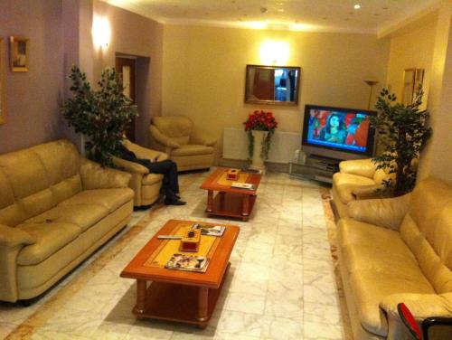 a large living room with couches and a tv at City Inn Express Hotel in London