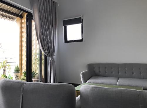 a living room with a couch and a window at DaLaHa City in Da Lat