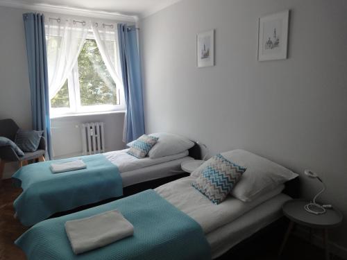 a living room with two beds and a window at Apartament Jasny in Częstochowa