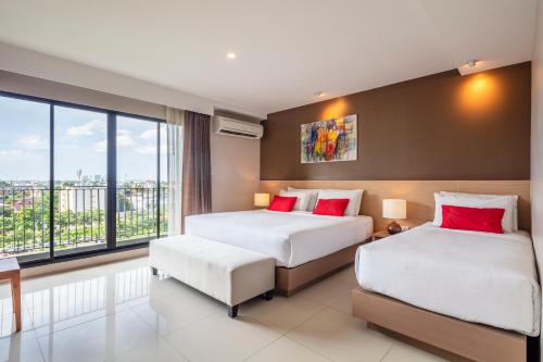 a hotel room with two beds and a window at Livotel Hotel Kaset Nawamin Bangkok in Bangkok