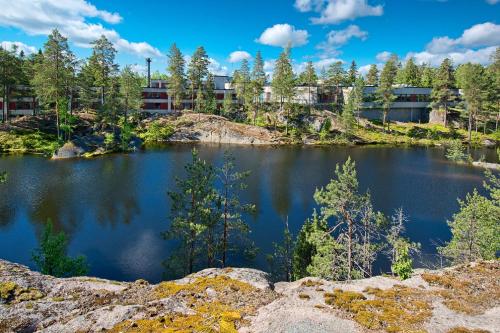 a view of a lake with buildings in the background at Hotel Korpilampi in Espoo