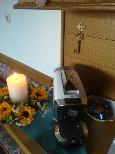a candle sitting next to a coffee maker and flowers at Haus Heckenrose in Westendorf