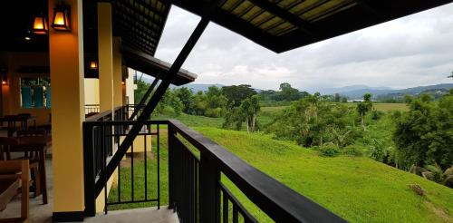 a balcony of a house with a view of a field at Baan Sakuna Hotel in Chiang Khong
