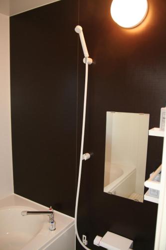 a bathroom with a mirror and a light on the wall at Yakunoyado Taguchi in Yakushima
