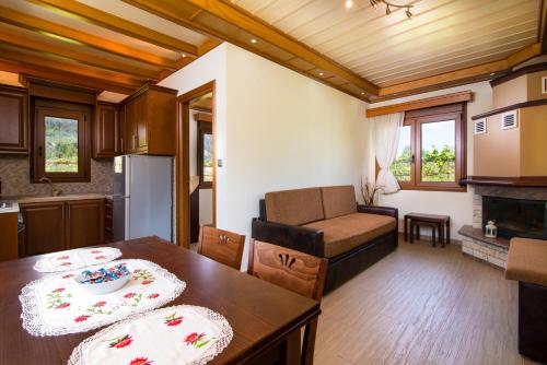 een keuken en een woonkamer met een tafel en een bank bij Semiramis Cottage in Chrysi Ammoudia
