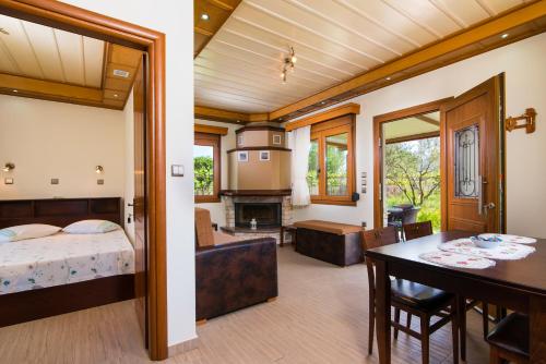 a bedroom with a bed and a dining room at Semiramis Cottage in Chrysi Ammoudia