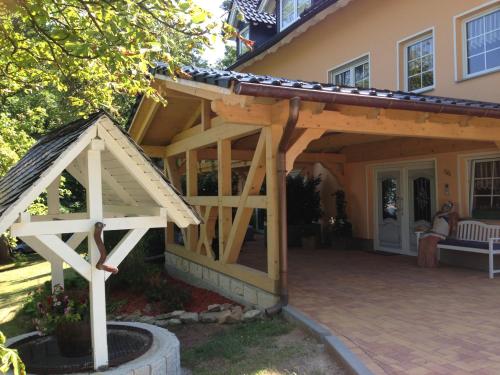 een houten pergola aan een huis bij Ferienwohnung Am Eichenberg in Blankenburg