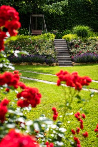 a garden with red flowers in the grass at Boutique-Hotel Alter Gerichtshof in Hartberg
