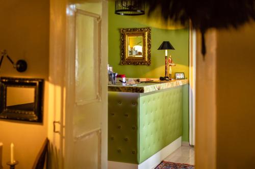 ein Badezimmer mit grünen Wänden und einem Waschtisch mit einem Spiegel in der Unterkunft Boutique-Hotel Alter Gerichtshof in Hartberg