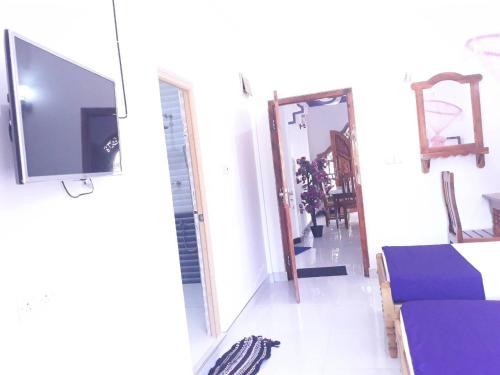 a living room with a tv and a couch at SNP Star Guest House in Trincomalee