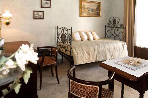 a bedroom with a bed and a table and chairs at Casa Del Grande Vecchio in Airasca