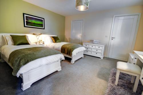 a bedroom with two beds and a desk and a chair at Chapelhill in Helensburgh