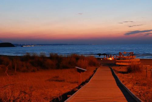 a wooden path leading to the beach at sunset at Al Faro Bianco B&B e Residence con parcheggio in Vasto
