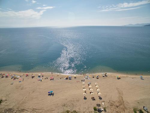 a group of people on a beach with umbrellas at Albatros Suites in Nea Vrasna