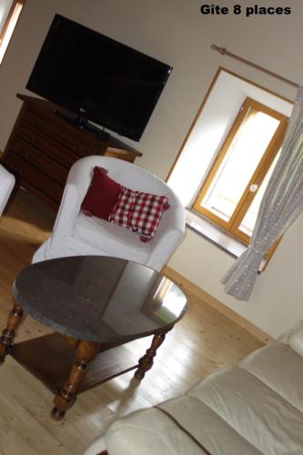 - un salon avec une chaise blanche et une table dans l'établissement Gites typiques au coeur des Hautes Vosges, à Saulxures-sur-Moselotte