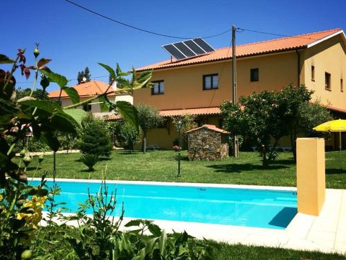 a house with a swimming pool in front of a house at Casa Cova do Barro in Janeiro de Cima