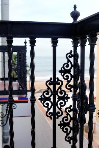 a black iron railing with a view of the ocean at Hotel Playa de Regla in Chipiona