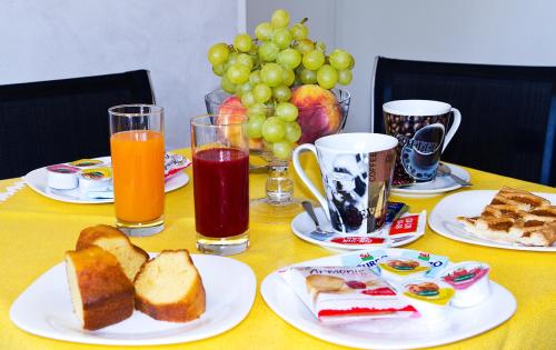 a table with plates of food and glasses of juice at Ca' del Faro Bibione in Bibione