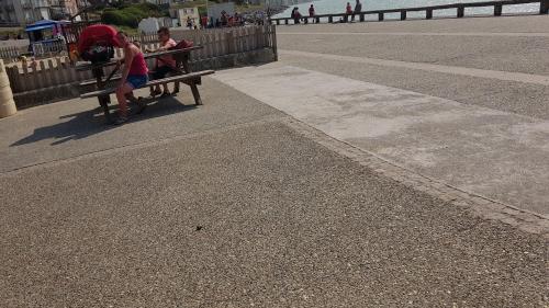 a group of people sitting on a bench near the ocean at Appartement centre village vue mer - Relais Fleuri in Ault