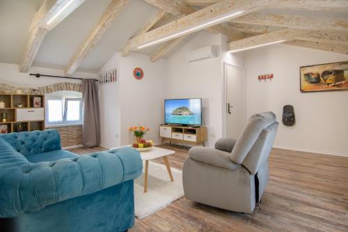 a living room with two blue couches and a tv at Apartments Borgo 8 in Tar