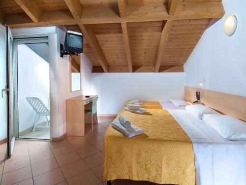 una camera con un grande letto e una TV sul soffitto di Hotel Miramare a Cattolica