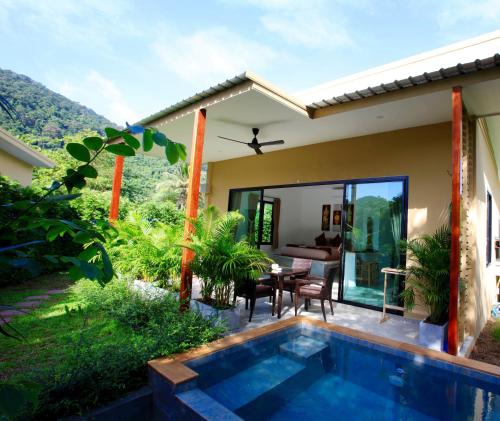 a villa with a swimming pool in front of a house at The Great Escape Chalets in Thong Nai Pan Yai