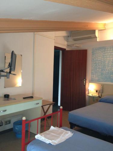 a hotel room with a bed and a desk and a television at Hotel Rivamare in Massignano