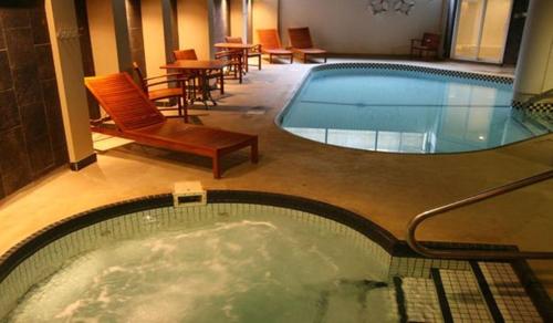 a swimming pool in a hotel with chairs and tables at le Georgesville in Saint-Georges