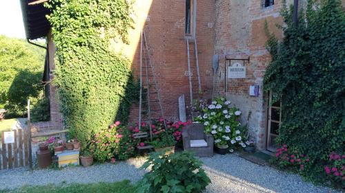 a garden with flowers and plants in front of a brick building at I Conti della Serva in Cinzano