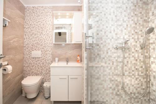 een badkamer met een douche, een toilet en een wastafel bij Apartments Miraflores in Split
